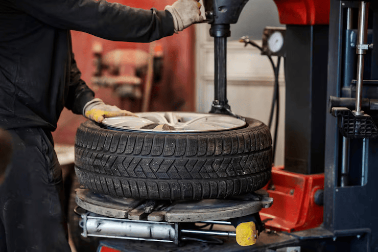 auto-mechanic-working-with-service-equipment-vulcanizing-car-tire_232070-22420