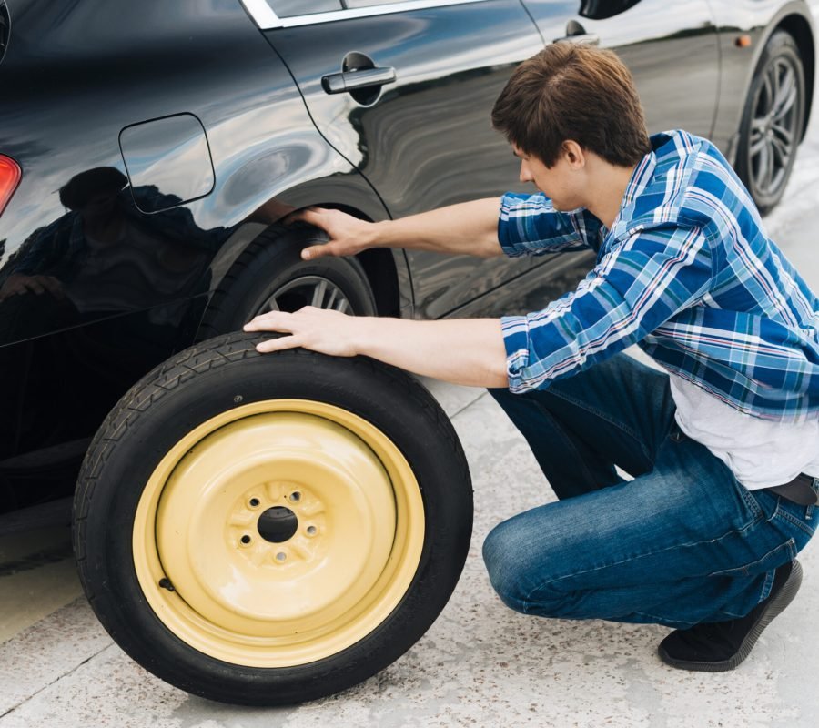 full-shot-man-changing-car-tire
